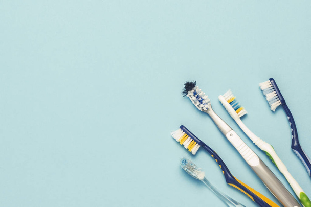 Verschillende tandenborstels gebruikt op een blauwe achtergrond. Tandenborstel wijzigen concept, mondhygiëne, grote en vriendelijke familie. Plat lag, top uitzicht. - Foto, afbeelding