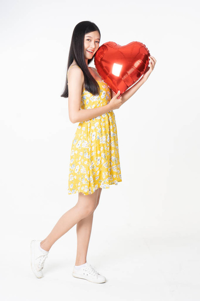 Asian young woman in yellow dress hold  red balloon heart. Young - Foto, Imagem