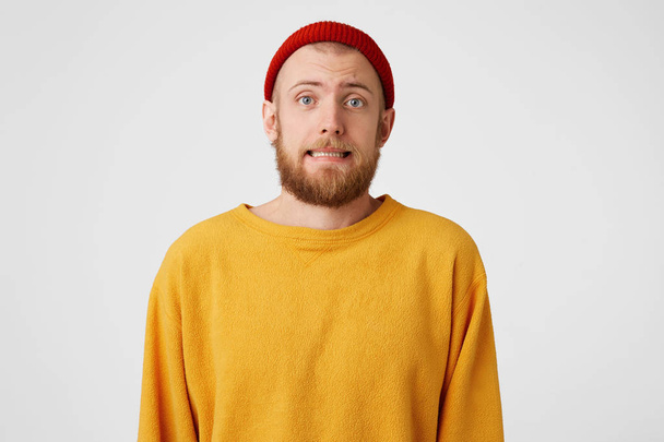 Unsure doubters young man with a red beard is very nervous, can't relax, a man should talk to someone, but hesitates to come up,isolated on white background - Photo, Image