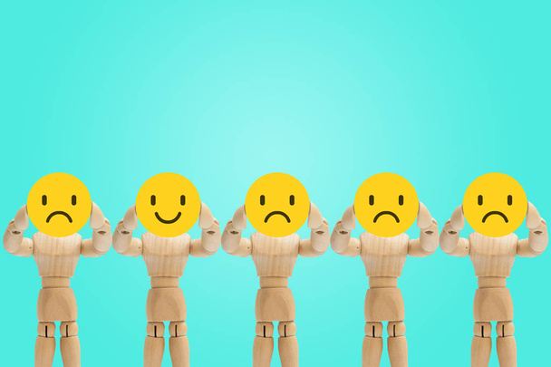 Група дерев'яних фігур манекен стоїть і тримає емоції обличчя в смутку і щасті
. - Фото, зображення