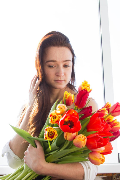 Молодая девушка с большим букетом тюльпанов
 - Фото, изображение
