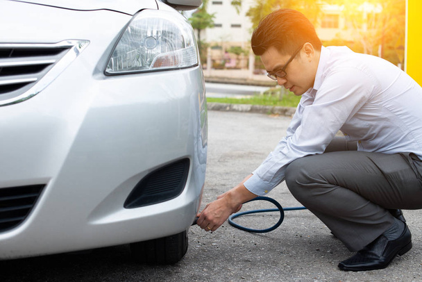 asian man pumping air to his car tire - Φωτογραφία, εικόνα