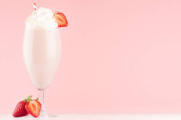 Exquisite light milk strawberry dessert with juicy slice berry, whipped cream, straw on modern elegant pink color background. - Фото, изображение