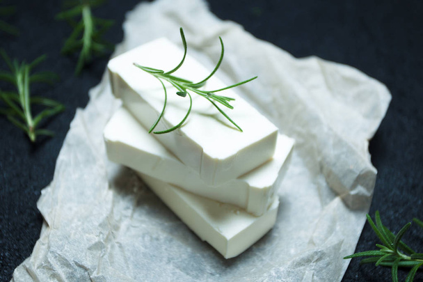 Organic goat cheese feta with rosemary on parchment paper. - Fotoğraf, Görsel