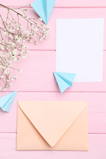 Beige envelope with paper planes and gypsophila flowers on woode - Photo, Image
