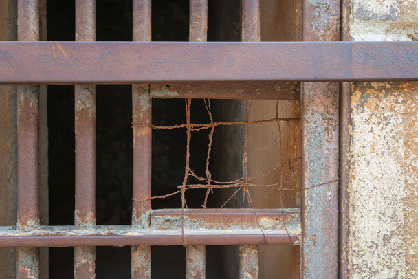 Крупный план закрытой ржавой железной решетки двери камеры в закрытой заброшенной тюрьме в Каире Цитадель, Египет
 - Фото, изображение