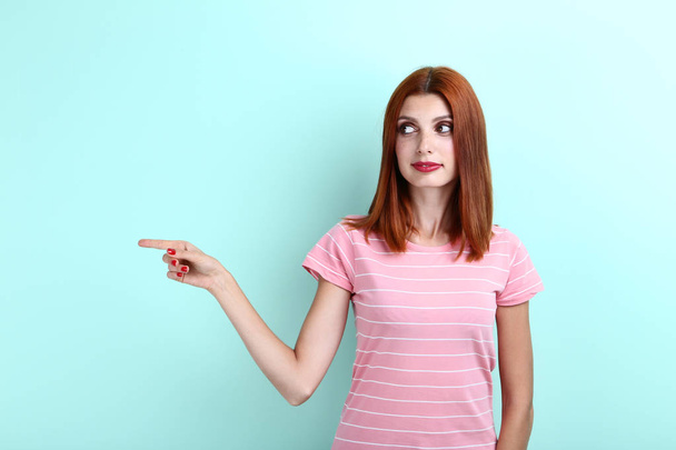 Young redhaired woman on mint background - Foto, Imagen
