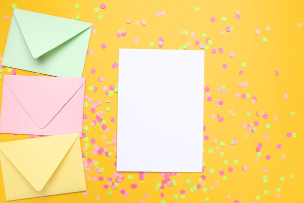 Colorful envelopes with blank paper and confetti on yellow backg - Foto, Imagem