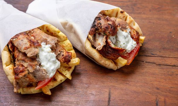 Gyro pita, shawarma, take away, street food. Traditional greek turkish, meat food on wooden table - Valokuva, kuva