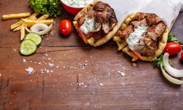 Gyro pita, shawarma, take away, street food. Traditional greek turkish, meat food on wooden table - Photo, Image