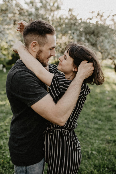 Портрет щасливої усміхненої пари закоханих насолоджуйтесь один одним у квітковому саду
 - Фото, зображення