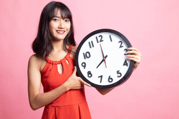 Young Asian woman with a clock. - Фото, зображення