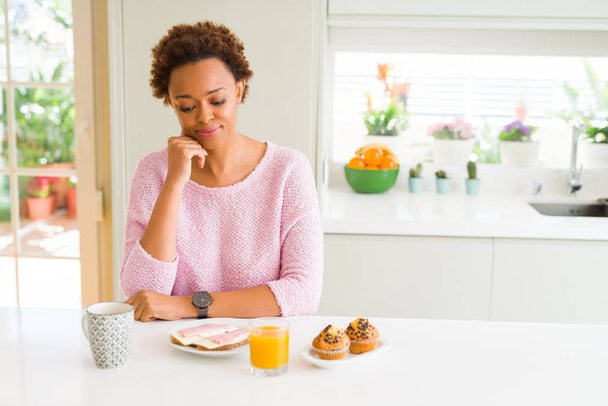 Evde el çene düşünme hakkında soru, dalgın ifade ile sabah breaksfast yiyen genç Afro-Amerikan kadın. Düşünceli yüzüyle gülümsüyor. Şüphe kavramı. - Fotoğraf, Görsel