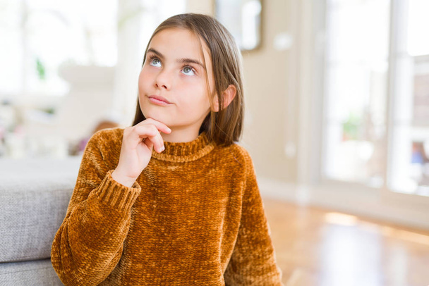 Krásná mladá dívka dítě nosí ležérní svetr s rukou na bradě přemýšlet o otázce, zamyšlený výraz. Usmívající se zamyšlenou tváři. Pochybnost koncept. - Fotografie, Obrázek