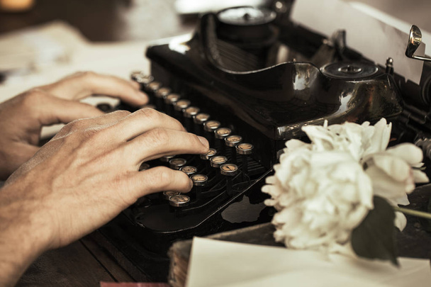 Les mains d'un jeune homme tapant sur une machine à écrire vintage antique
 - Photo, image
