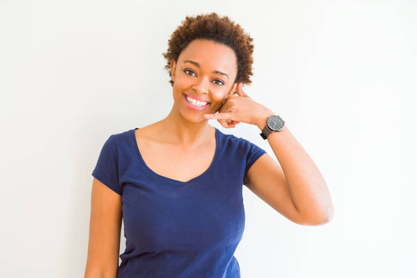 Νέοι όμορφη αφρικανική αμερικανική γυναίκα σε άσπρο φόντο, χαμόγελο κάνει τηλέφωνο χειρονομία με το χέρι και τα δάχτυλα σαν να μιλάμε στο τηλέφωνο. Επικοινωνία έννοιες. - Φωτογραφία, εικόνα