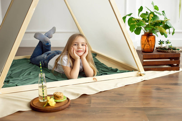 Cute happy little girl playing with toys and dreaming in teepee and bed - Foto, Bild