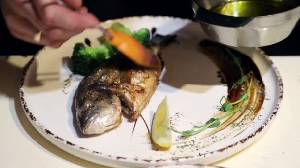 Рыба Дорадо на тарелке. Повара фирменное блюдо на тарелке с лимоном и травами
 - Кадры, видео