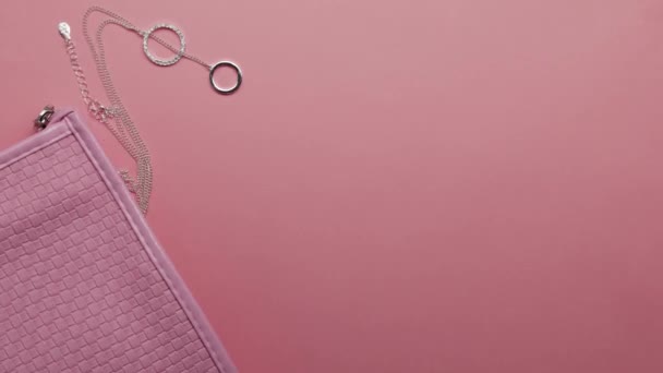 Conjunto de cosméticos para mujeres sobre fondo de papel rosa, animación stop motion de vista superior
 - Metraje, vídeo