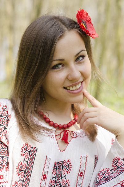 Portrait of beautiful smiling girl with flower of poppy in hair - Фото, зображення