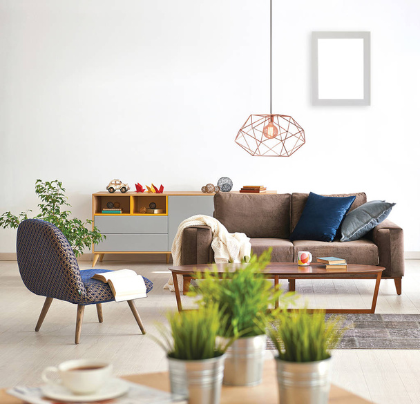 Modern woonkamer concept met close-up tafel vaas van plant en bank fauteuil lamp achtergrond stijl. - Foto, afbeelding