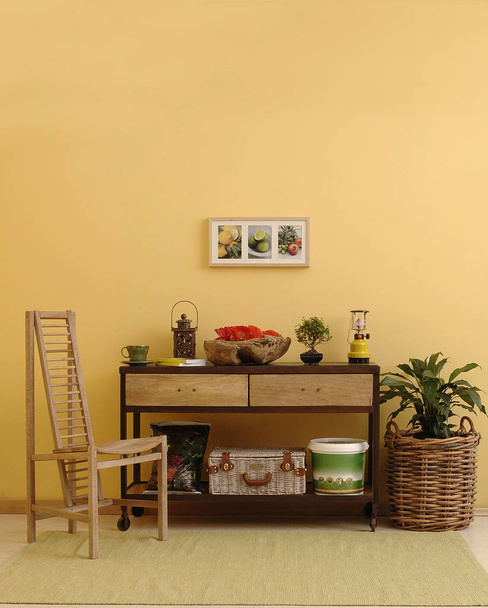 装飾的な木製の椅子とキャビネットの椅子スタイルの黄色の壁. - 写真・画像