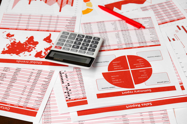 Rapports rouges, graphiques et calculatrice pour le calcul des finances sur bureau. Concept de comptabilité financière des entreprises
 - Photo, image