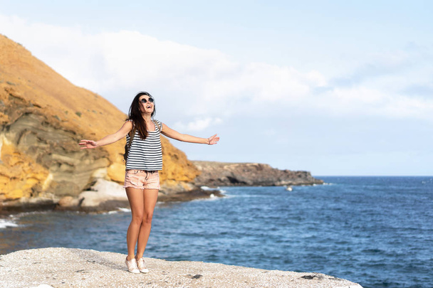 Pretty tourist brunette girl having fun outdoor near sea. - Fotó, kép