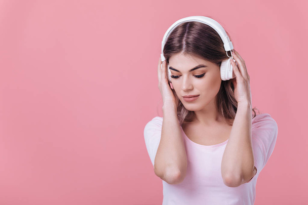 beautiful blonde woman in white headphones listens to music - Photo, Image