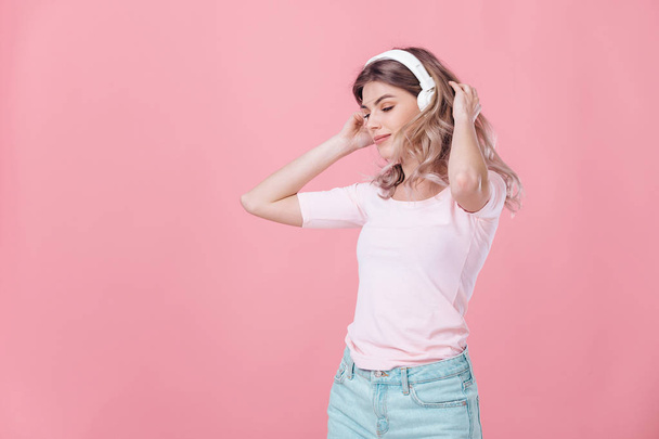 hermosa mujer rubia en auriculares blancos escucha música
 - Foto, Imagen