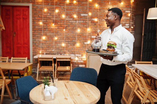 Young african american waiter man hold tray with burger at resta - Photo, image