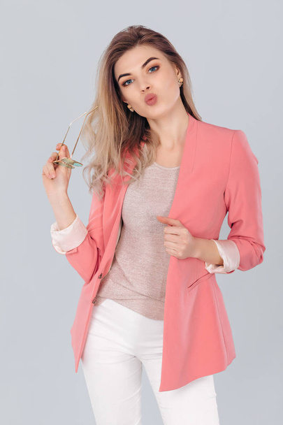 blonde woman in pastel casual jacket posing in studio. - 写真・画像