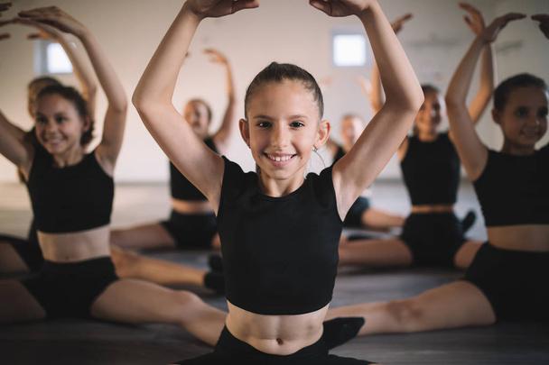 Group of fit children exercising ballet in studio together - Photo, Image