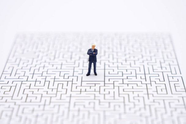 Miniature people businessmen standing in the center of the maze. - Photo, Image