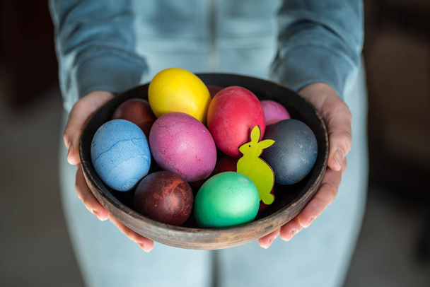 Colorful Easter eggs in bowl in woman's hands.  - Фото, изображение