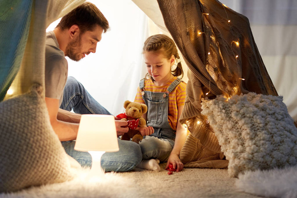 happy family playing with toy in kids tent at home - Foto, imagen