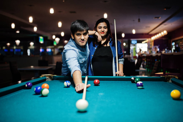 Stylish asian couple wear on jeans playing pool billiard on bar. - Zdjęcie, obraz