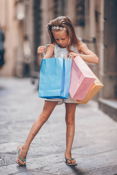 Portrét Rozkošná holčička chodí s nákupní tašky venku v evropském městě. - Fotografie, Obrázek