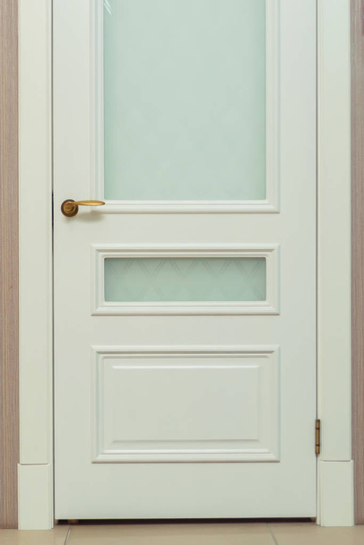 Puerta blanca. El diseño clásico de la puerta interior. Puerta moderna con una banda de platina y vidrio
. - Foto, imagen