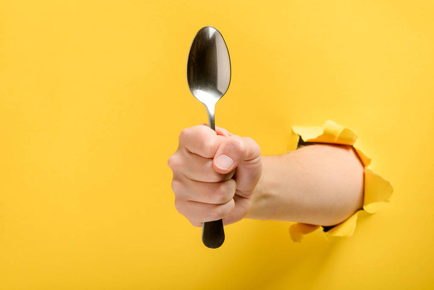 Hand giving a spoon - Foto, afbeelding