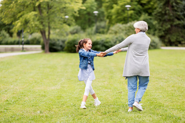бабушка и внучка играют в парке
 - Фото, изображение