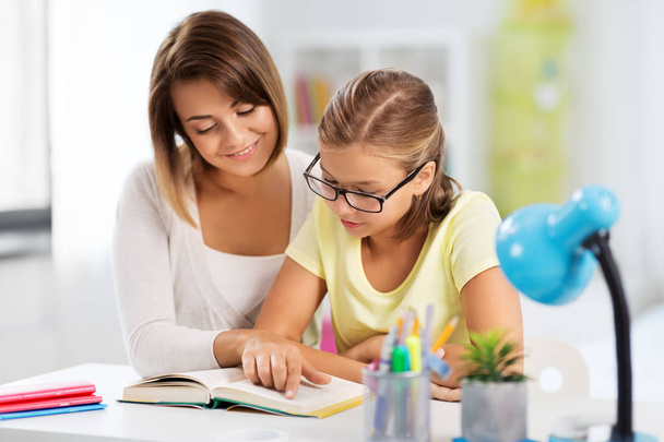 mother and daughter doing homework together - Foto, afbeelding