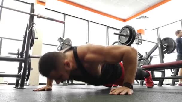 RUSSIA, TOGLIATTY - FEBRUARY 23, 2019: Young sports man performs pushups in the gym. The athlete is engaged in fitness - Záběry, video