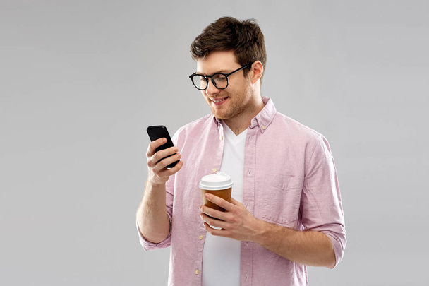 man in glasses with smartphone drinking coffee - Фото, зображення
