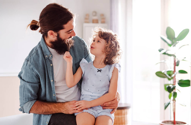 A small girl with young father at home, talking. Copy space. - Photo, image