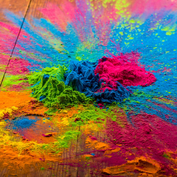 Abstract colorful Happy Holi background. Color vibrant powder on wood. Dust colored splash texture. Flat lay holi paint decoration - Fotoğraf, Görsel