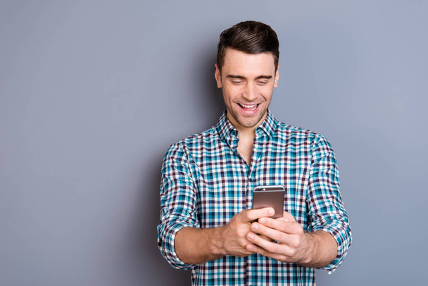 Close up photo attractive amazing he him his man arms hands new telephone smart phone  look interest laugh laughter wearing casual plaid checkered shirt outfit isolated grey background - Foto, Imagen