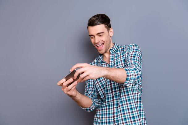 Close up photo attractive amazing macho he him his man arm hand telephone smart phone having fun addicted video games  wearing casual plaid checkered shirt outfit isolated grey background - Φωτογραφία, εικόνα