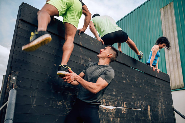 Les participants au mur d'escalade du parcours d'obstacles - Photo, image