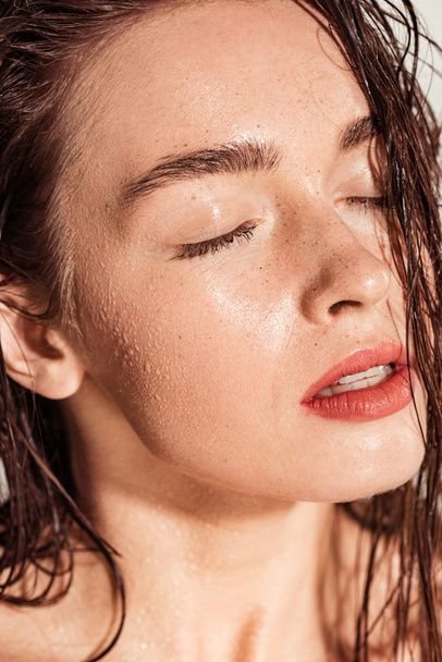 beautiful young woman with coral lips, eyes closed and wet hair  - Fotó, kép